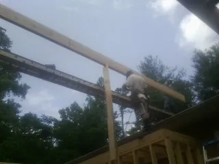 Carpenter setting a ridge beam over a new addition frame — Ice Dam Removal by Roofing Brothers in Dunreith