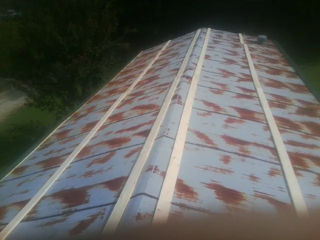 Rusted metal roof panels with new wood purlins before replacement — Storm Damage Roof Repair in Dunreith by Roofing Brothers