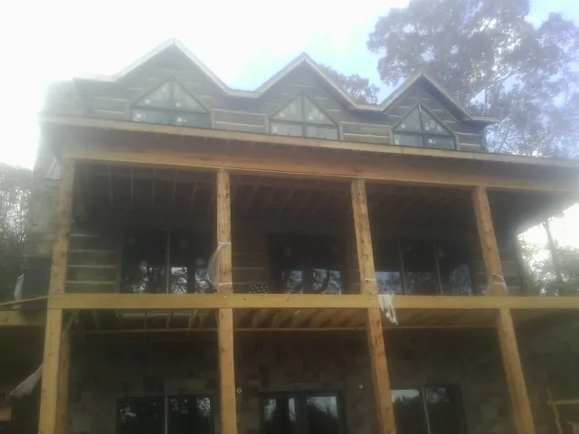 Dormers and porch framing on a large log home under construction — Roof Coating work by our crew in Dunreith