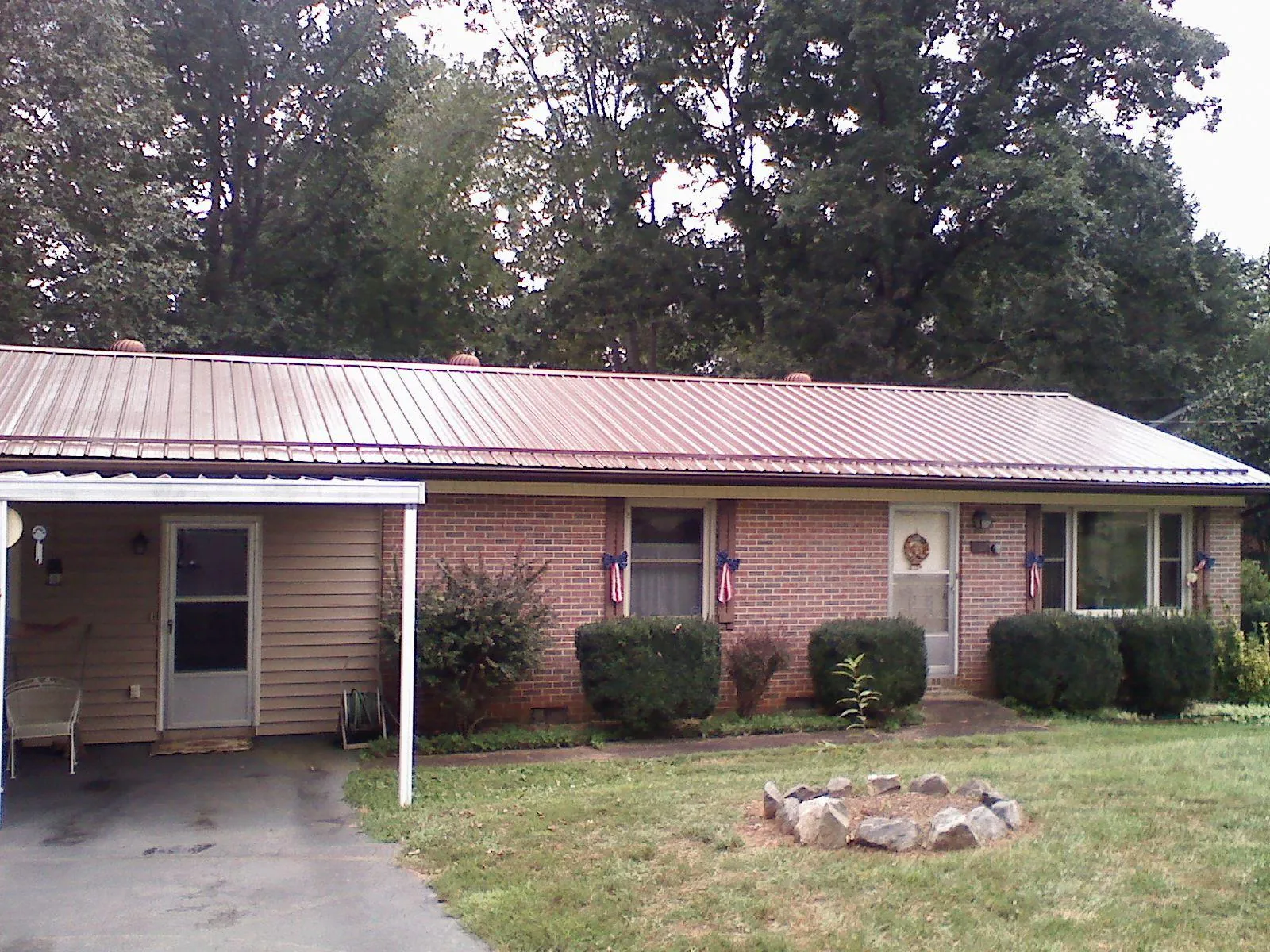 Bronze metal roof and carport on a brick ranch home — Roof Repair work by our crew in Dunreith
